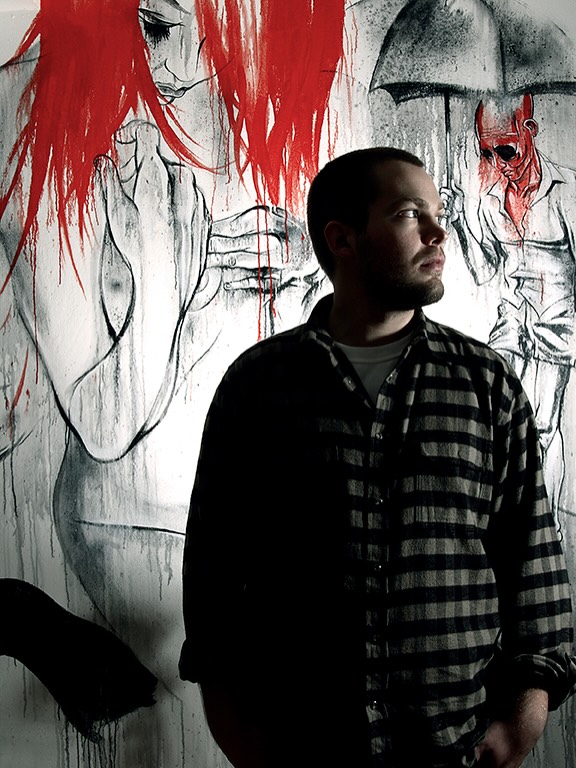 Ben Tour standing in front of a red-and-black mural