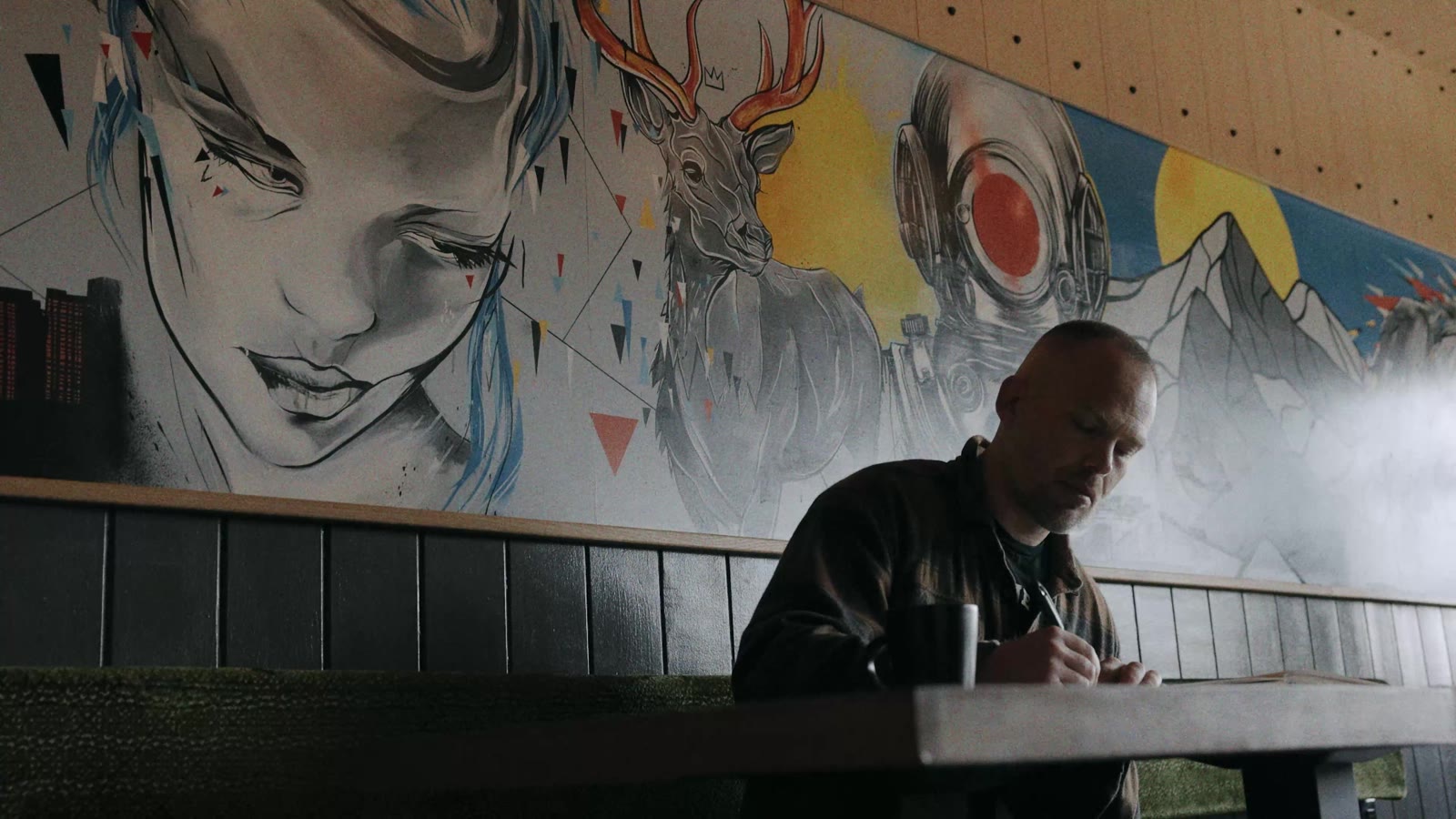 Ben Tour drawing in front of one of his murals